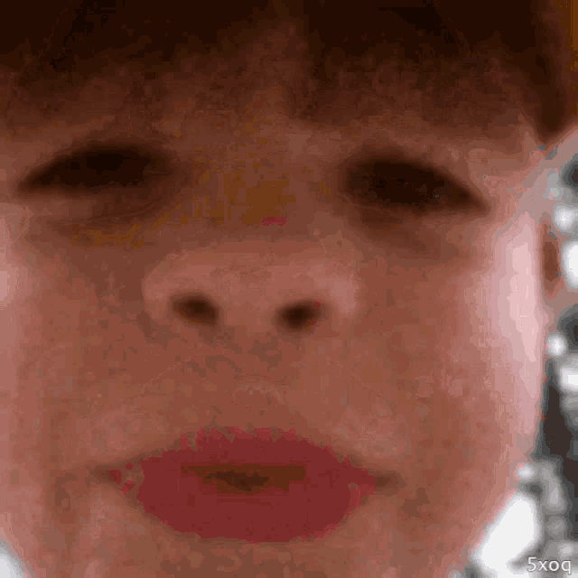 a close up of a person 's face with the words 5xq on the bottom right