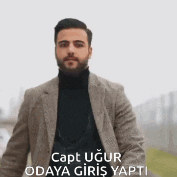 a man with a beard is wearing a suit and a turtleneck sweater .