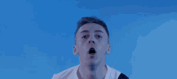 a man in a white shirt is making a funny face