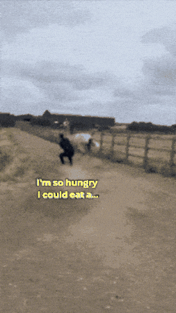 a man walking down a dirt road with the words " i 'm so hungry i could eat a "