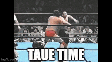 two men are wrestling in a ring with taue time written on the bottom of the screen .