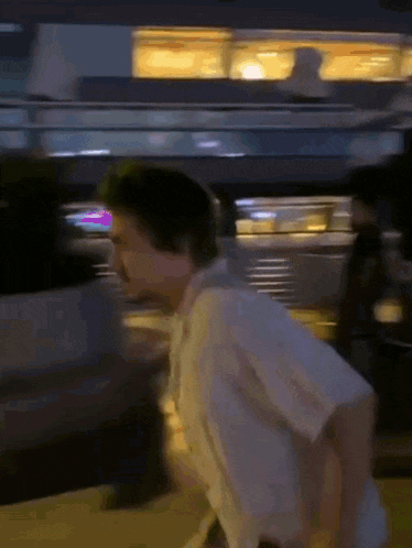 a blurry picture of a man walking down a street at night