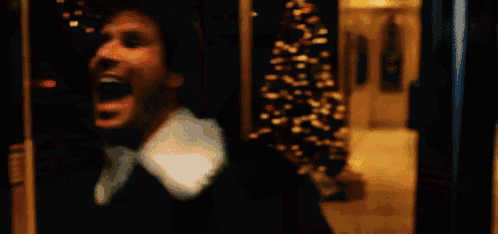 a man is laughing with his mouth wide open in a blurry photo .