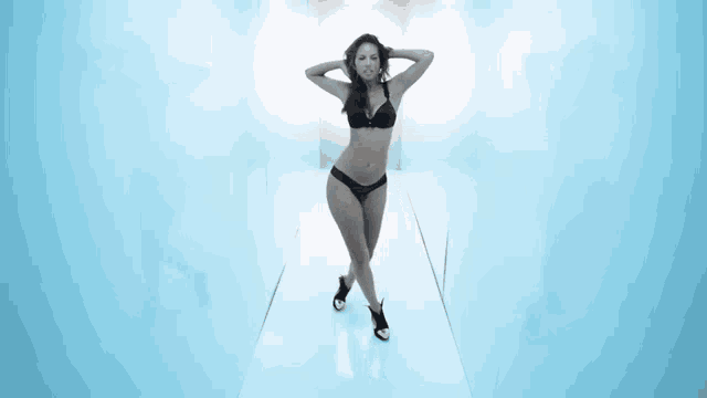 a woman in a black bikini is standing in a room