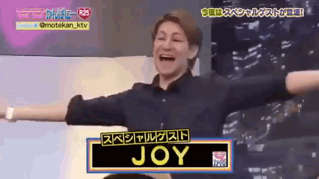 a man with his arms outstretched has joy written on a sign