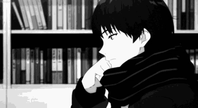 a black and white anime character is sitting in front of a bookshelf with his hand on his chin .