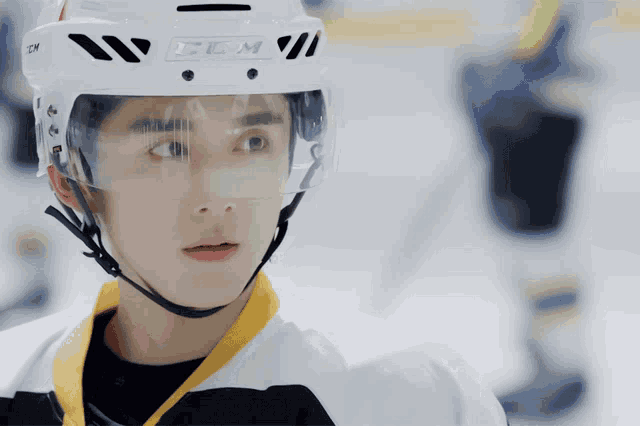 a hockey player wearing a white helmet with ccm on it