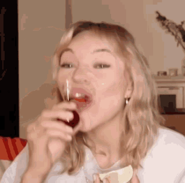 a woman is eating a lime and drinking a shot of wine .