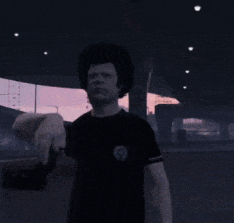 a man in a black t-shirt is pointing his finger at something