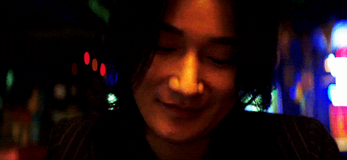 a close up of a woman 's face with a blurry background and a sign that says ' a ' on it