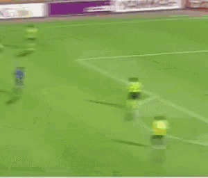 a soccer goalie stands in front of a goal with a sign in the background that says ufo