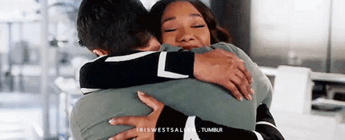 a man and woman are hugging each other in a room .
