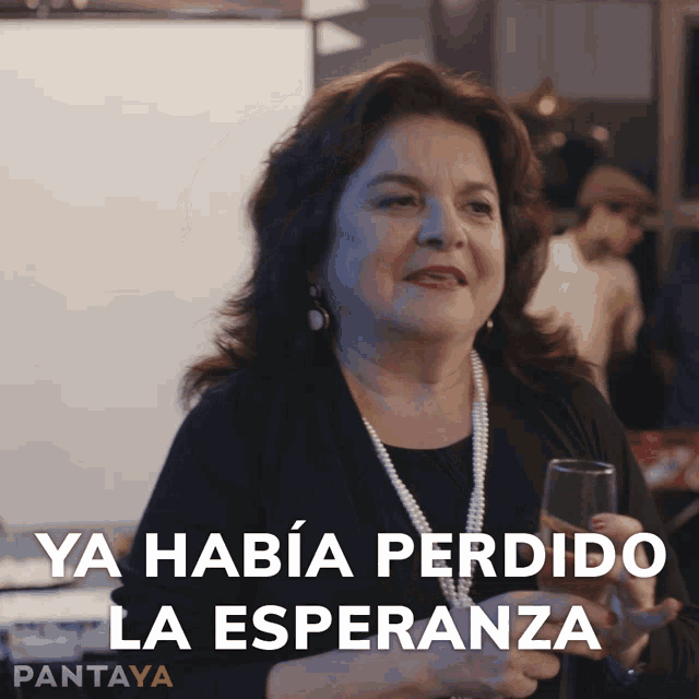a woman holding a glass with the words ya habia perdido la esperanza
