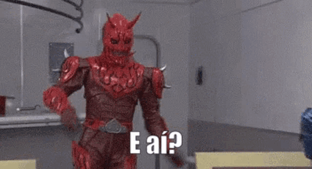 a man in a red devil costume is standing in a room with the words e ai .
