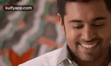 a close up of a man 's face with his eyes closed smiling .