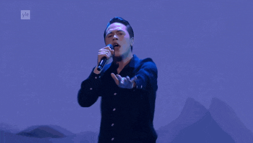a man singing into a microphone with the letters yle on the bottom right