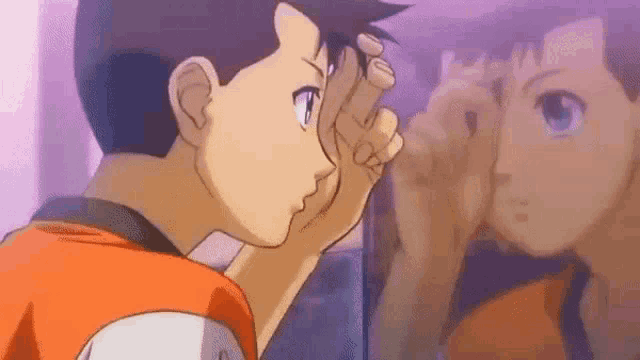 a boy is looking at himself in the mirror .
