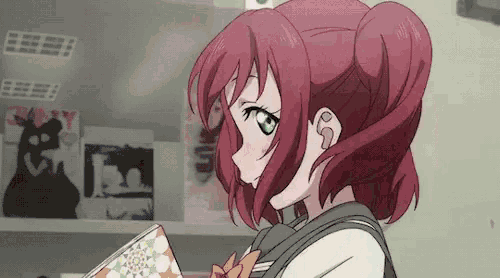 a girl with red hair and green eyes is standing in front of a shelf with books .