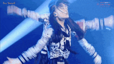 a girl in a school uniform is performing on stage with her arms outstretched and the words free yourself on the bottom