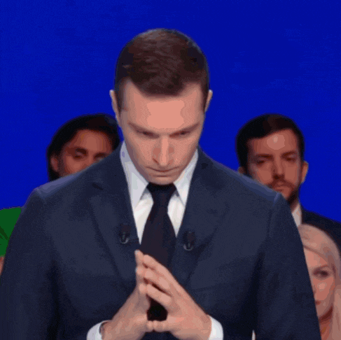 a man in a suit and tie is standing in front of a blue screen