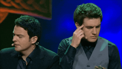 two men are standing next to each other on a stage and one has a microphone on his neck
