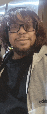 a man with glasses and a beard wearing an adidas jacket