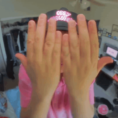 a young man wearing a pink shirt and a hat that says only world rides