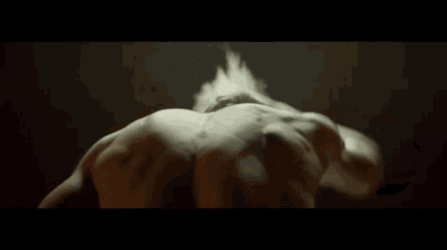 a man 's back is shown in a dark room