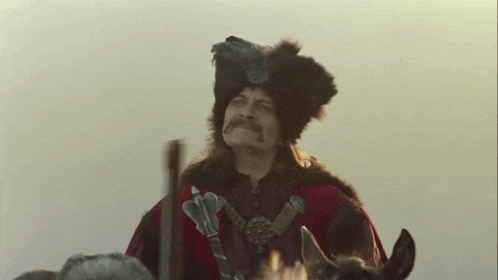 a man with a mustache is riding a horse in a costume