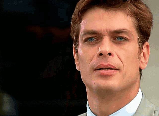 a close up of a man 's face with a dark background