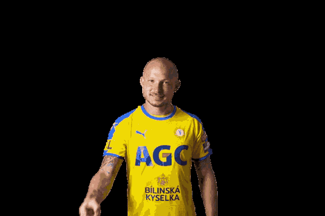 a man wearing a yellow and blue agc shirt