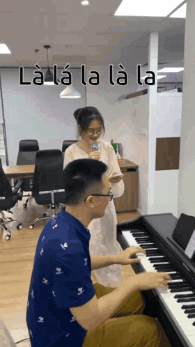 a man playing a piano next to a woman singing into a microphone