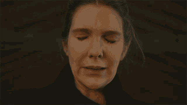 a close up of a woman 's face with her mouth open