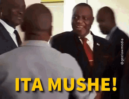 a man in a suit and tie is standing next to another man with the words ita mushe above him