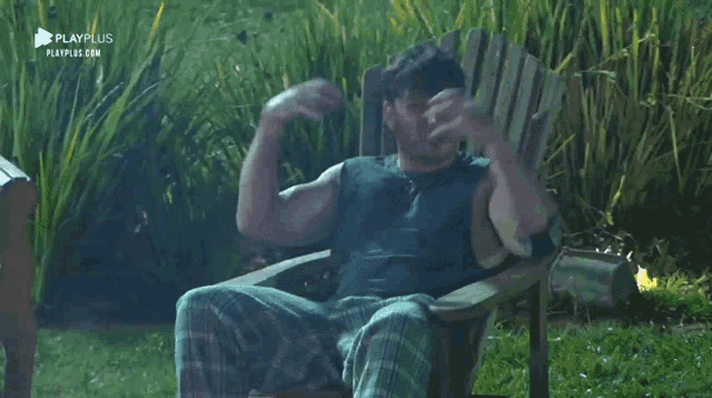 a man is sitting in a chair in front of a fire with playplus written on the bottom