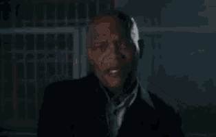 a man in a suit and tie is crying in the dark .
