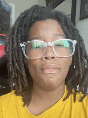 a person with dreadlocks wearing clear glasses