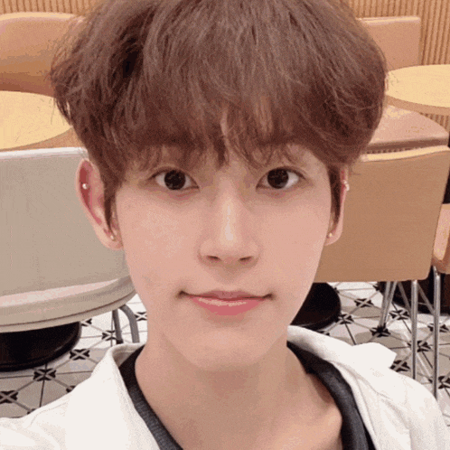 a young man with a piercing in his ear takes a picture of himself