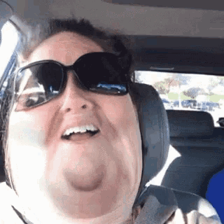 a woman wearing sunglasses and headphones is making a funny face
