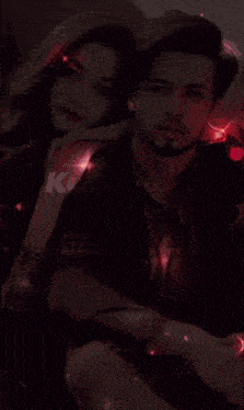 a man and a woman are surrounded by red lights with the letter k on the bottom