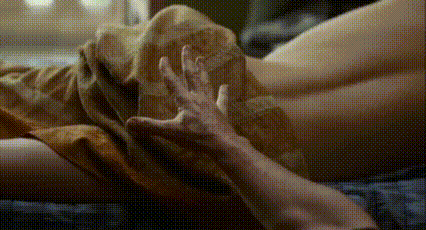 a close up of a person laying on a bed with their hands on their feet .