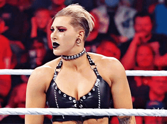a woman in a wrestling ring with a choker on her neck