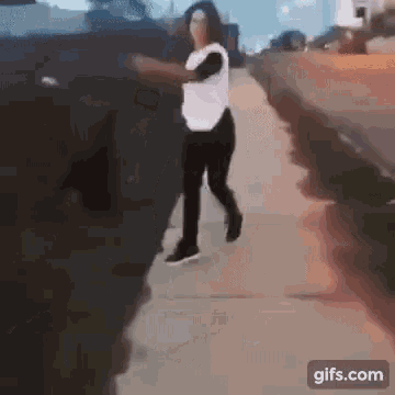 a woman is walking down a sidewalk in a blurry photo .