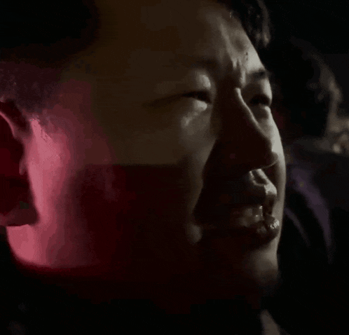 a close up of a man 's face with a red background .