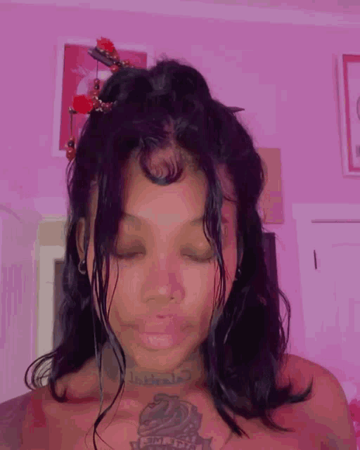 a woman with a tattoo on her chest is wearing a hair clip with red flowers