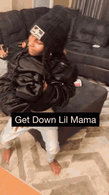 a person in a black jacket is holding a baby with the caption get down lil mama on the bottom
