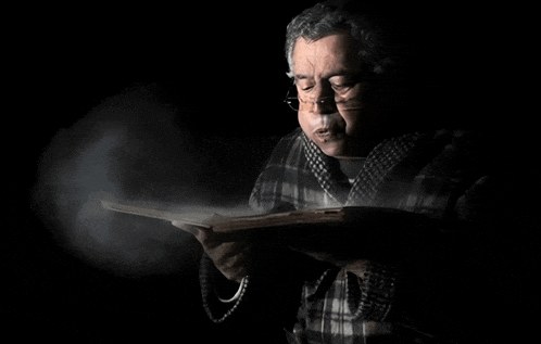 a man in a plaid shirt is reading a book with smoke coming out of his mouth