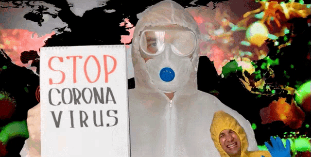 a man in a protective suit holding a sign that says stop corona virus