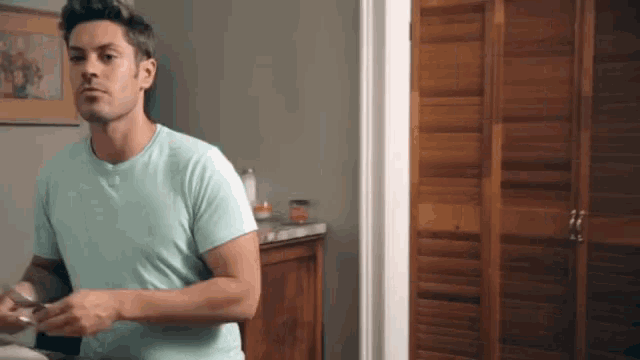 a man in a light blue shirt is standing in a room