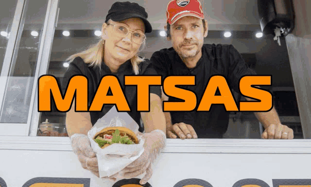 a man and woman holding a hamburger in front of a sign that says matsas